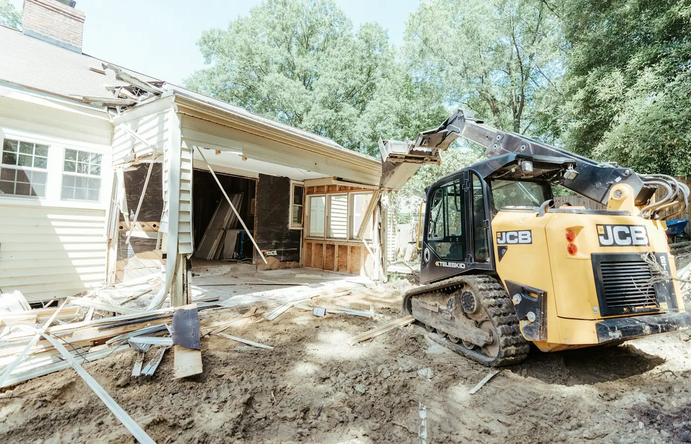 Existing house wall opened up with a compact loader to prepare for a building addition (stock photo)