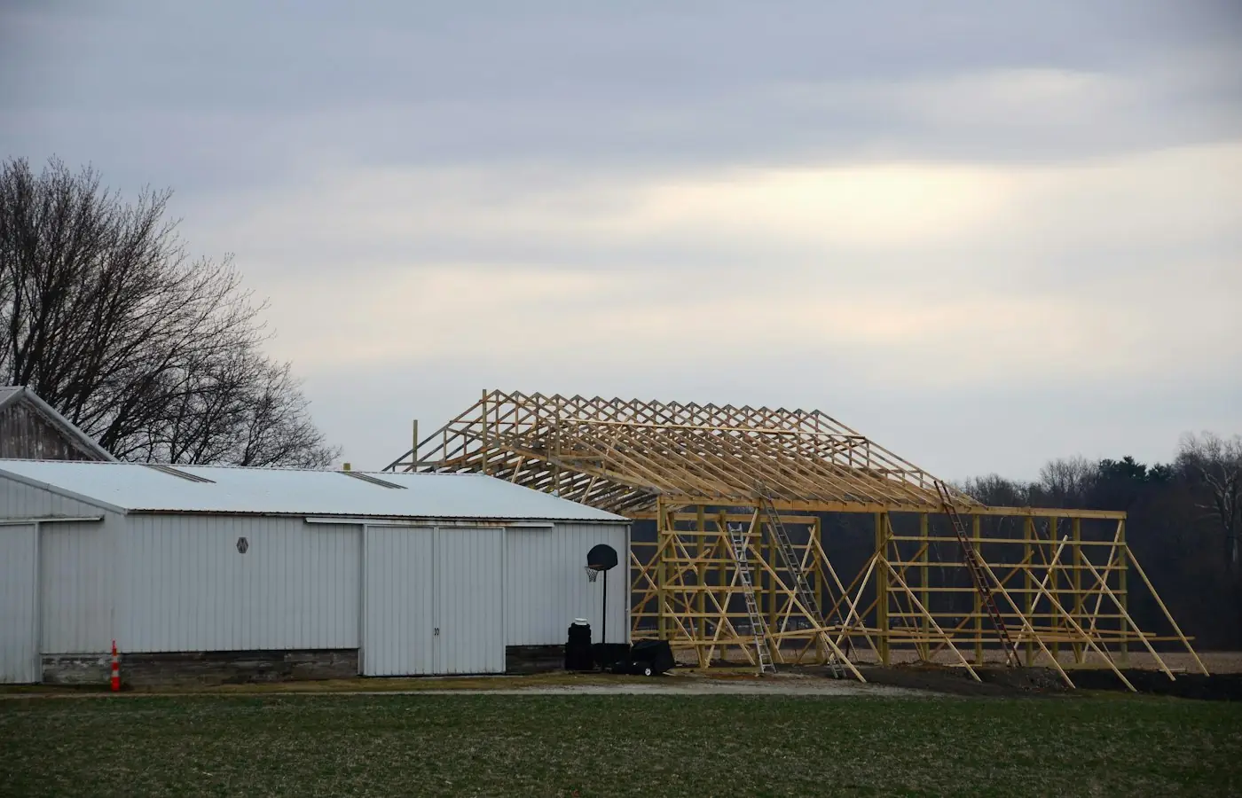 Roof trusses and wood framing of an addition going up beside an existing building (stock photo)