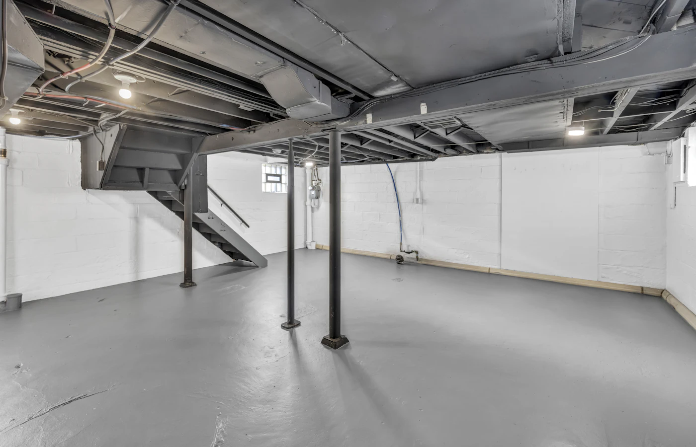 Basement with new concrete slab and steel support columns after excavation (stock photo)
