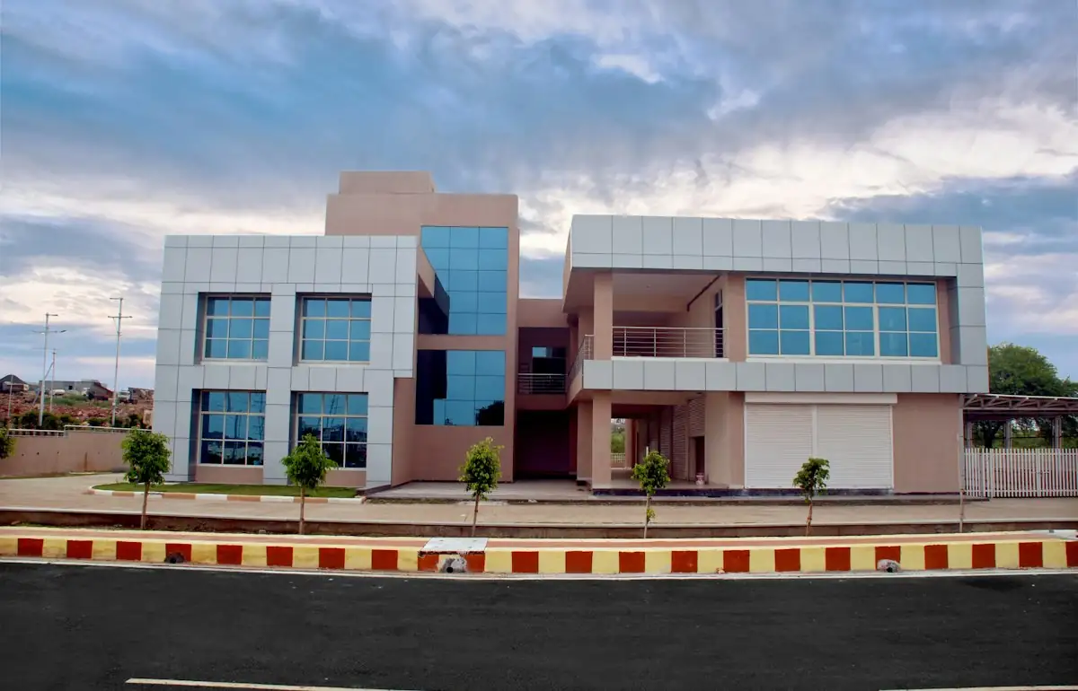 A modern commercial building with glass windows and metal panels beside a paved road (stock photo)