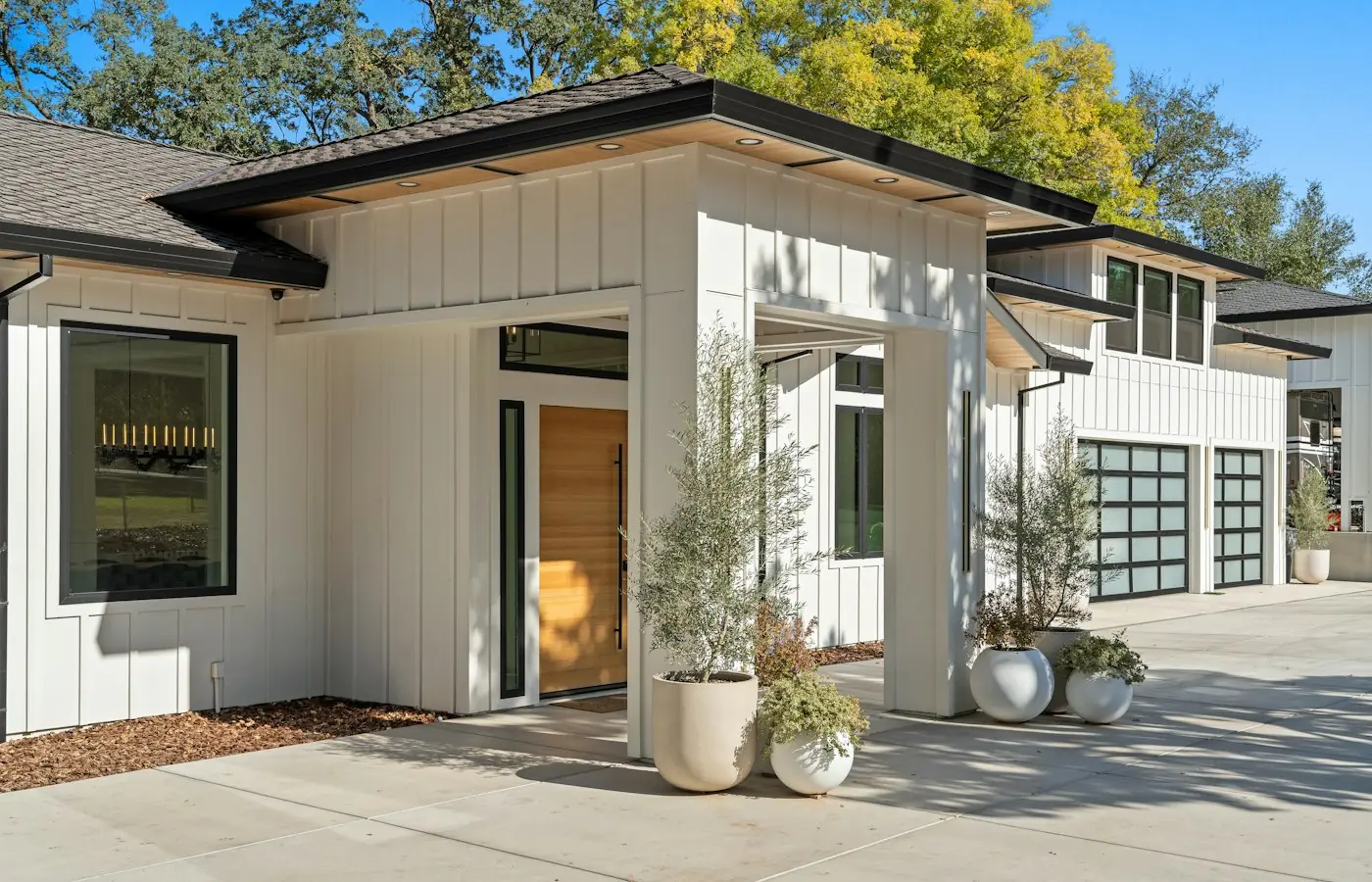 Finished modern home exterior with a new wing and timber entry (stock photo)