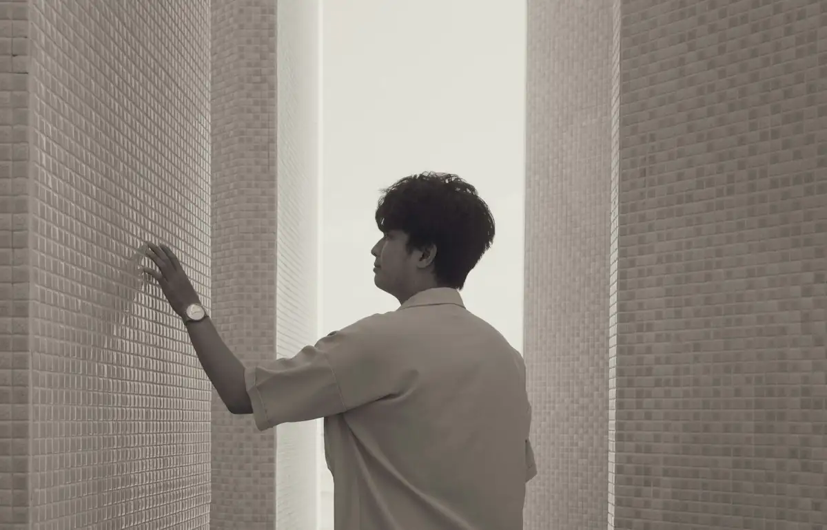 Man touching textured wall in a modern hallway (stock photo)
