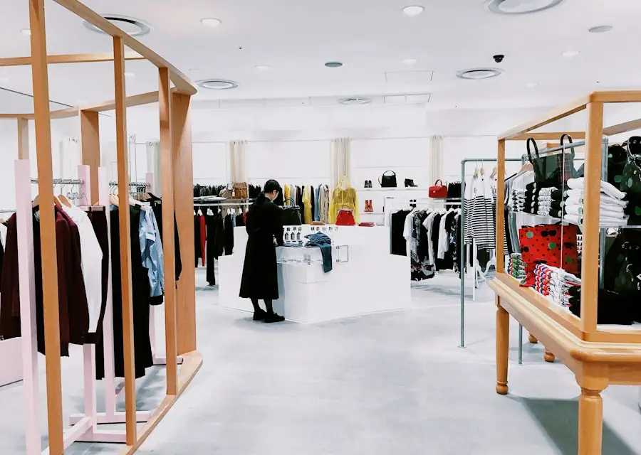 Bright modern retail store interior with clothing displays (stock photo)